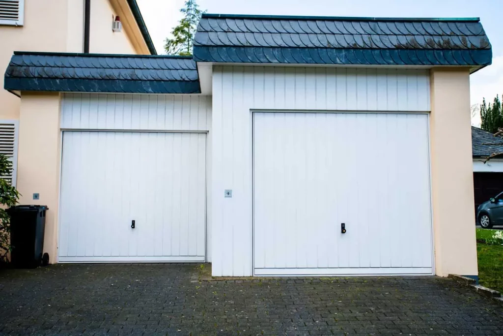 White residential garage doors representing local service reach for garage door business consulting