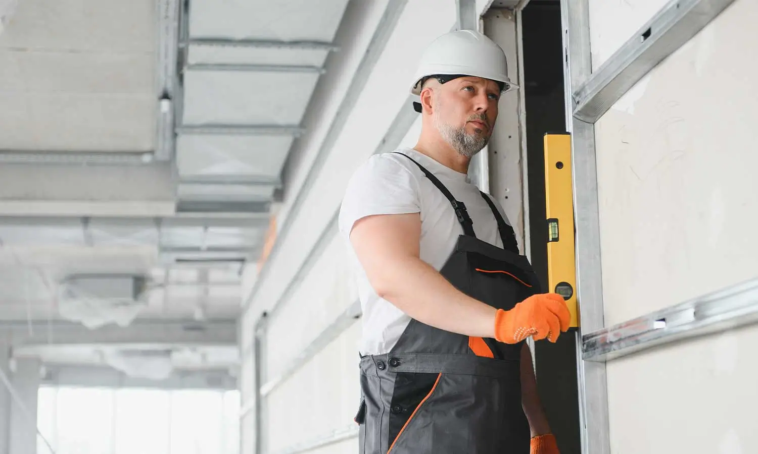 A technician using a level to ensure proper garage door installation, showcasing the attention to detail valued by a garage door marketing agency