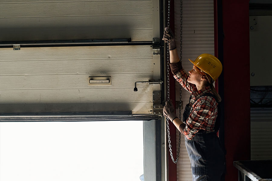 Woman raising garage door in workplace setting
